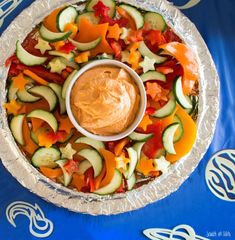 a platter filled with cucumbers, carrots and other veggies