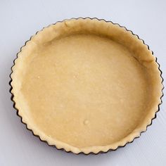 an uncooked pie crust in a pan on a table with a sticker next to it