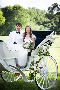 a bride and groom sitting in a horse drawn carriage