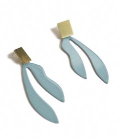 two pairs of blue and gold earrings on a white background, one is shaped like an earring