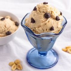 an ice cream sundae with chocolate chips in a blue glass bowl on a white tablecloth