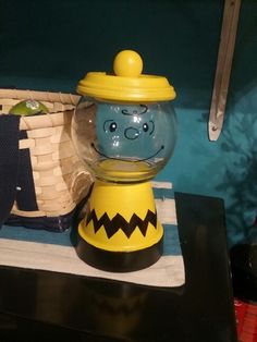 a yellow and blue gummy machine sitting on top of a table next to a basket