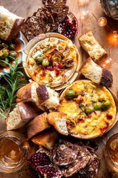 an assortment of food and drinks on a table with bread, olives, cranberry sauce