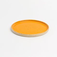 a yellow plate sitting on top of a white table