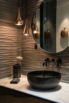 a bathroom sink sitting under a round mirror in front of a wall mounted faucet