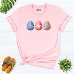 Easter day egg shirt, Easter bunny egg shirt, Easter Day gift, Easter Eggs Shirt, Kids Easter Shirt, Egg Hunting Shirt, women Easter day tee Hello! Thank you for supporting small businesses. My main priority here is the satisfaction of my customers. My t-shirts are Bella+Canvas brand. If Bella+Canvas is out of stock, I will send it from a brand of the same size and quality. If you want to see this design on the SWEATSHIRT you can buy it from the link below.https://etsy.me/3LS0Viz T-shirts are co Cute Easter Tops With Graphic Print, Cute Graphic Print Tops For Easter, Fun Spring T-shirt As A Gift, Fun Spring T-shirt Perfect For Gifts, Spring Fun T-shirt, Pink Crew Neck Top With Bunny Design, Fun Spring T-shirt, Playful Easter Tops With Graphic Print, Easter Graphic Print Playful Tops