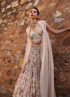 Dive into elegance with this ensemble: an embellished printed choli paired harmoniously with an embellished cape and a printed circular skirt. This ensemble captures attention with its intricate detailing and vibrant prints, offering a perfect blend of tradition and contemporary style. Ideal for weddings, festive celebrations, or cultural events, it promises to make a striking statement. Bohemian Sets With Dupatta And Cape Sleeves, Bohemian Sets With Cape Sleeves For Festive Occasions, Bohemian Set With Sheer Dupatta And Cape Sleeves, Navratri Dresses With Sheer Dupatta And Cape Sleeves, Bohemian Georgette Sets With Cape Sleeves, Pink Lehenga With Dupatta And Cape Sleeves, Festive Pink Lehenga With Cape Sleeves, Navratri Dresses With Cape Sleeves, Festival Georgette Lehenga With Cape Sleeves