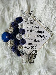 a graduation cap decorated with blue flowers and butterflies on a white furnishing area