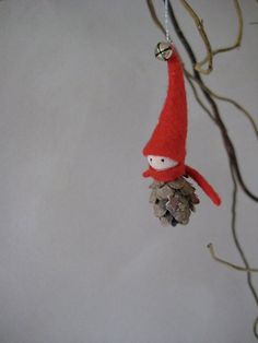 a red gnome ornament hanging from a tree branch