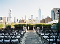 an outdoor ceremony set up in front of the city skyline