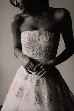 black and white photograph of a woman in a wedding dress with her hands on her hips