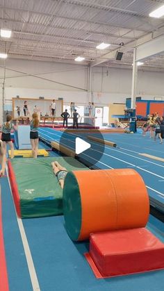 an indoor trampoline course with people in the background