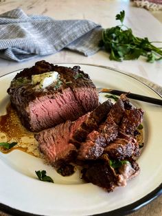 a white plate topped with steak and potatoes