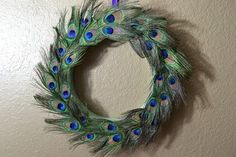 a peacock feather wreath hanging on the wall