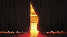 an open door leading to a stage with curtains on the sides and light coming through