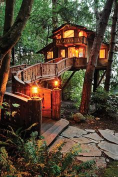 a tree house in the woods with stairs leading up to it