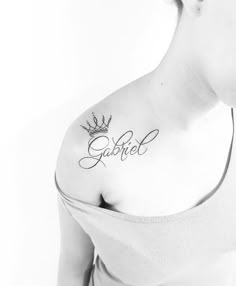 a woman with a crown tattoo on her chest and the word god written in cursive writing