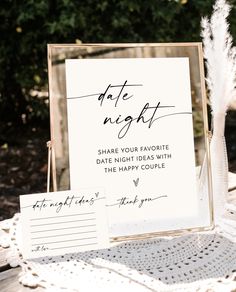 a table topped with a sign and two cards