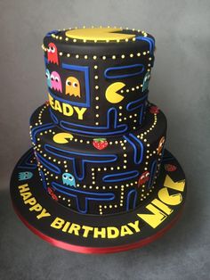 a three tiered birthday cake with pacman decorations on it's sides and the words, happy birthday mr