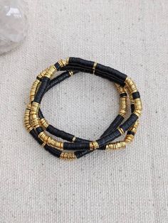 - African heishi vinyl disc beads with 16k heavy gold plated over brass disc accents- approx 4-4.5mm- stretchy- 7" Gold Stacked Heishi Beads Jewelry, Gold Heishi Beads Stretch Bracelet, Bohemian Black Heishi Beads Bracelet, Gold Stacked Heishi Beads Stretch Bracelet, Gold Heishi Beads Necklace Hand-strung, Handmade Black Heishi Beads, Bohemian Brown Heishi Beads, Yellow Heishi Beads Round Jewelry, Gold Stretch Bracelet With Hand-strung Heishi Beads