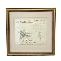 an old document with writing on it is in a gold frame and has been framed