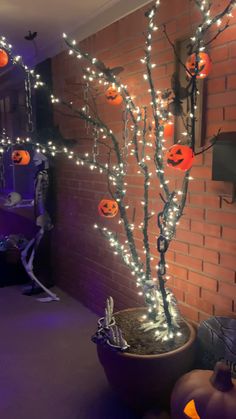 a halloween tree decorated with pumpkins and lights