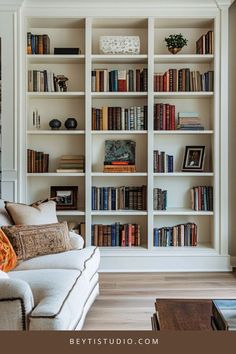 a living room filled with lots of books on top of a white book shelf next to a couch