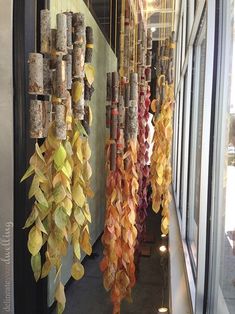 several wind chimes hanging from the side of a building next to a glass window