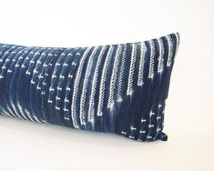 a blue and white striped pillow on a white background