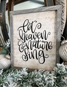 a wooden sign that says let heaven and nature sing on it next to christmas decorations