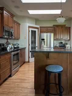 a kitchen with wooden cabinets and an island in front of the stove top oven is shown