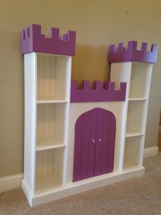 a purple and white castle shaped bookcase in a room with carpeted flooring