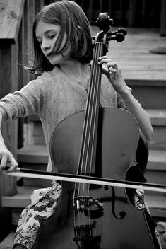 a woman playing the cello in black and white