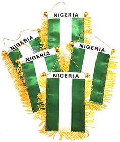 three green and white flags hanging from strings with gold trimmings on the ends