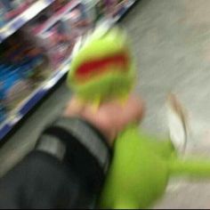 a blurry image of a person wearing a green jacket and hat in a store