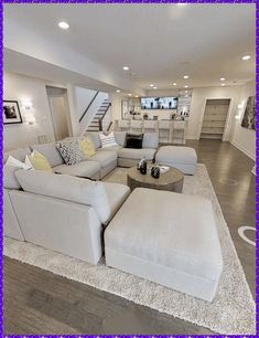 a living room filled with lots of furniture and a large rug on the floor in front of it