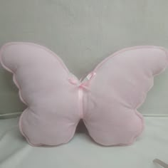 a pink butterfly shaped pillow sitting on top of a table