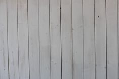 an orange and white cat sitting on top of a wooden floor next to a wall