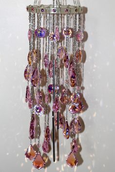 a chandelier with many different colored stones hanging from it's sides on a wall