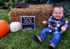 a baby sitting in the grass next to hay bales and pumpkins with a sign that says, we do not quite leave leaves are falling for me