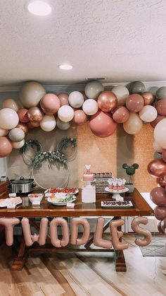 there is a table with balloons on it and the word twins spelled out in large letters