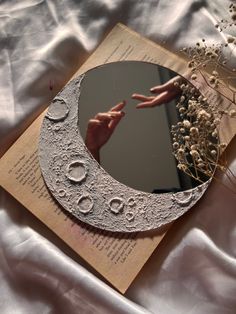 an altered photograph of someone reaching out to the moon with their hand on top of it