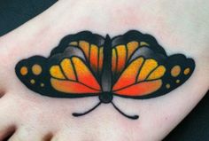 a butterfly tattoo is on the foot of a person's foot, which has yellow and black wings