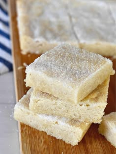 three pieces of cake sitting on top of a wooden cutting board with powdered sugar