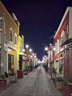 a cobblestone street lined with buildings at night