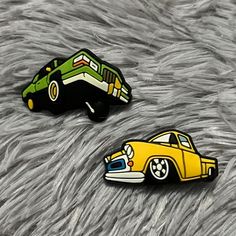 two yellow and green cars sitting on top of a furry surface