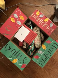 an open box filled with wrapped presents on top of a wooden floor