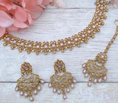 Beautiful Indian Bollywood choker necklace jewellery set with tikka headpiece & earrings.  Gold base with light antique gold & lilac stones.  Detailed with intricate pearl details to make this just so elegant.  Earring drop is: 5 cm  Perfect piece for bridesmaids and simple party guest wear. Indian Gold Jewellery Set, Tikka Headpiece, Purple Jewelry Set, Lilac Stone, Indian Choker, Indian Choker Necklace, Lehenga Designs Simple, Earring Drop, Pearl Details