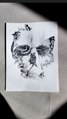 a black and white drawing of a butterfly with flowers on it's back side