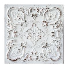 an old white wall with ornate designs on it